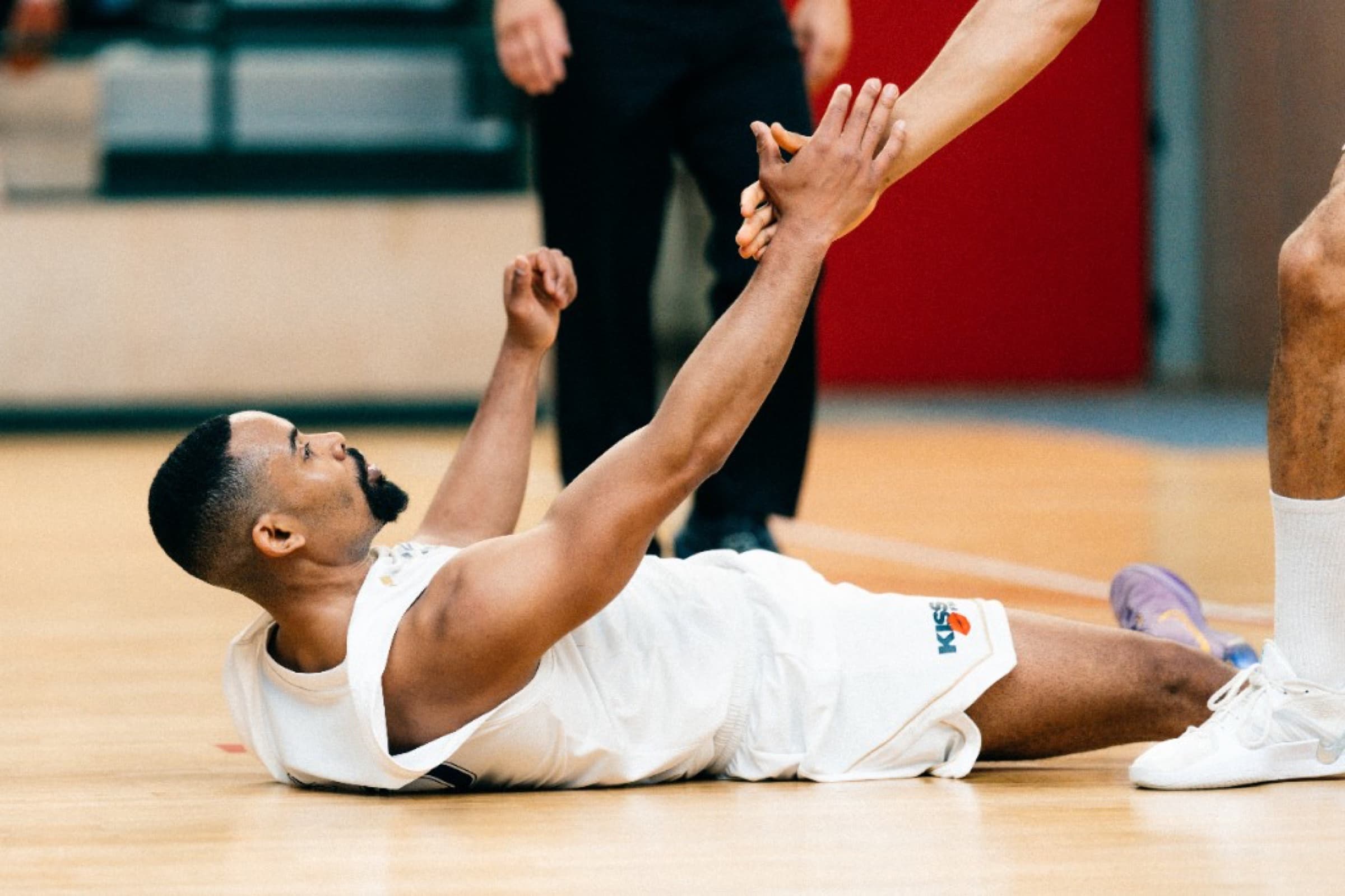 Player on the court floor reaching for a teammate’s hand — Berlin Dreams