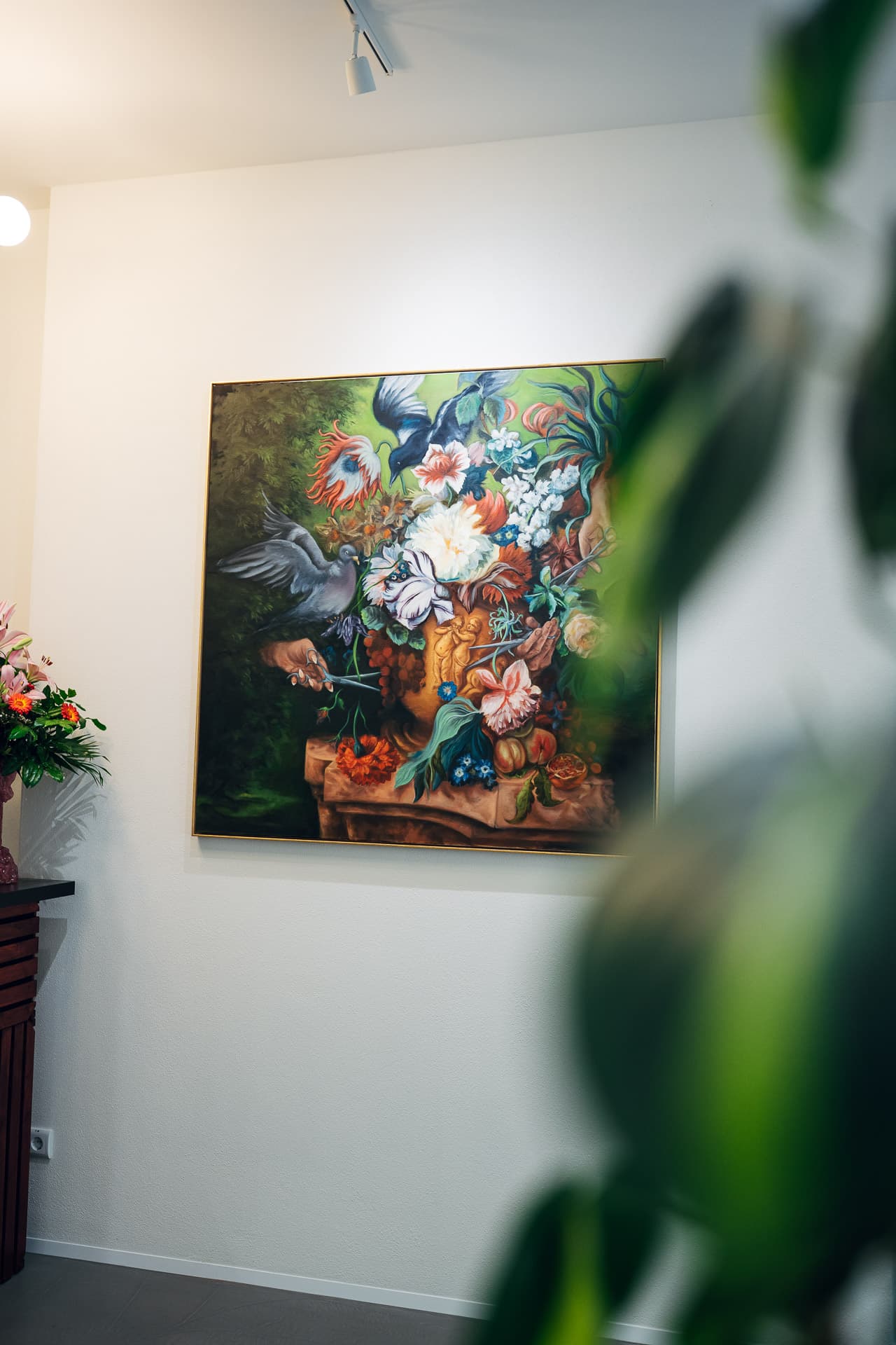 Großes Blumenstillleben an der Salonwand, echte Lilien und Pflanze im Vordergrund