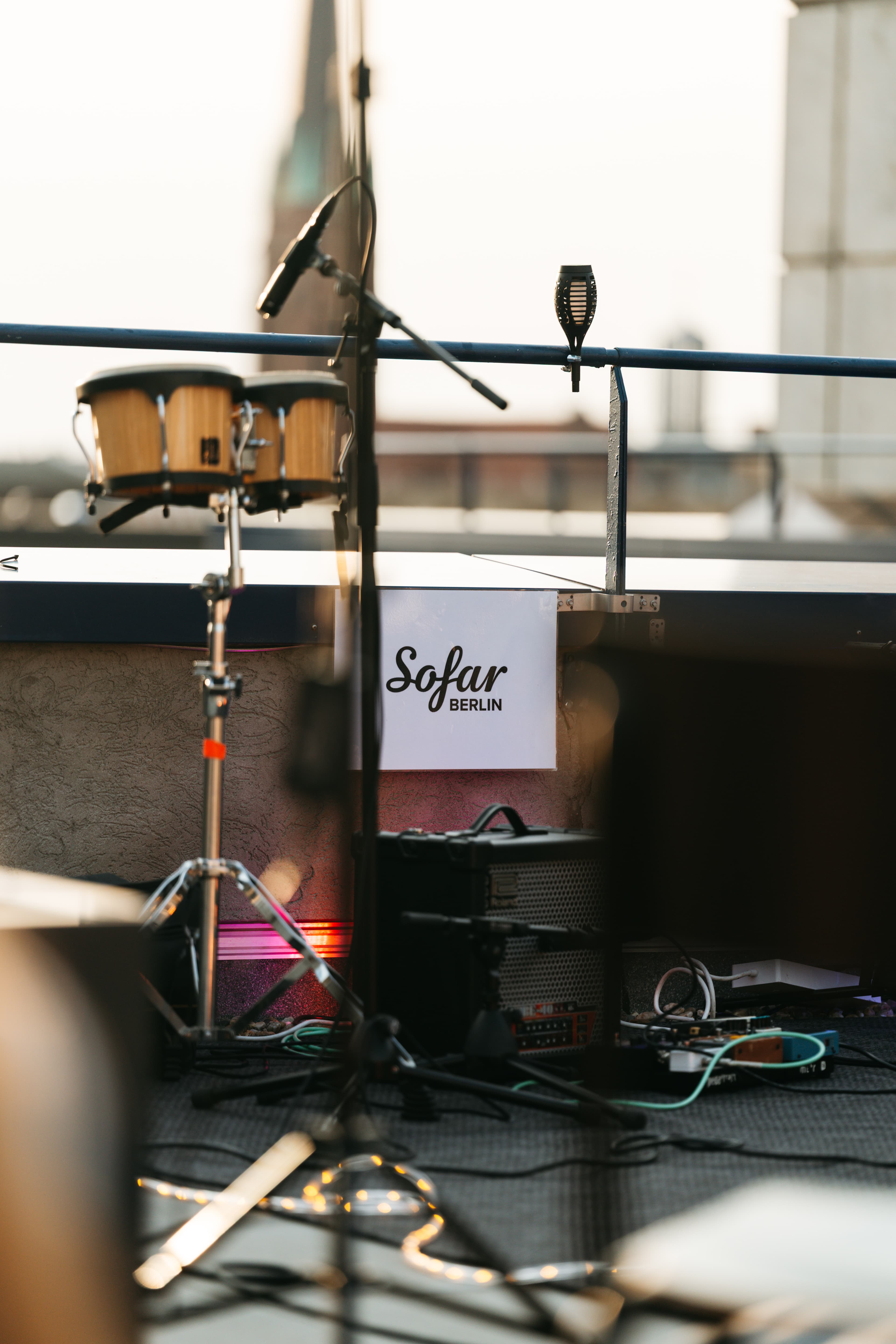 Bühne auf dem Dach: Bongos und Sofar-Berlin-Schild vor der Skyline bei Golden Hour