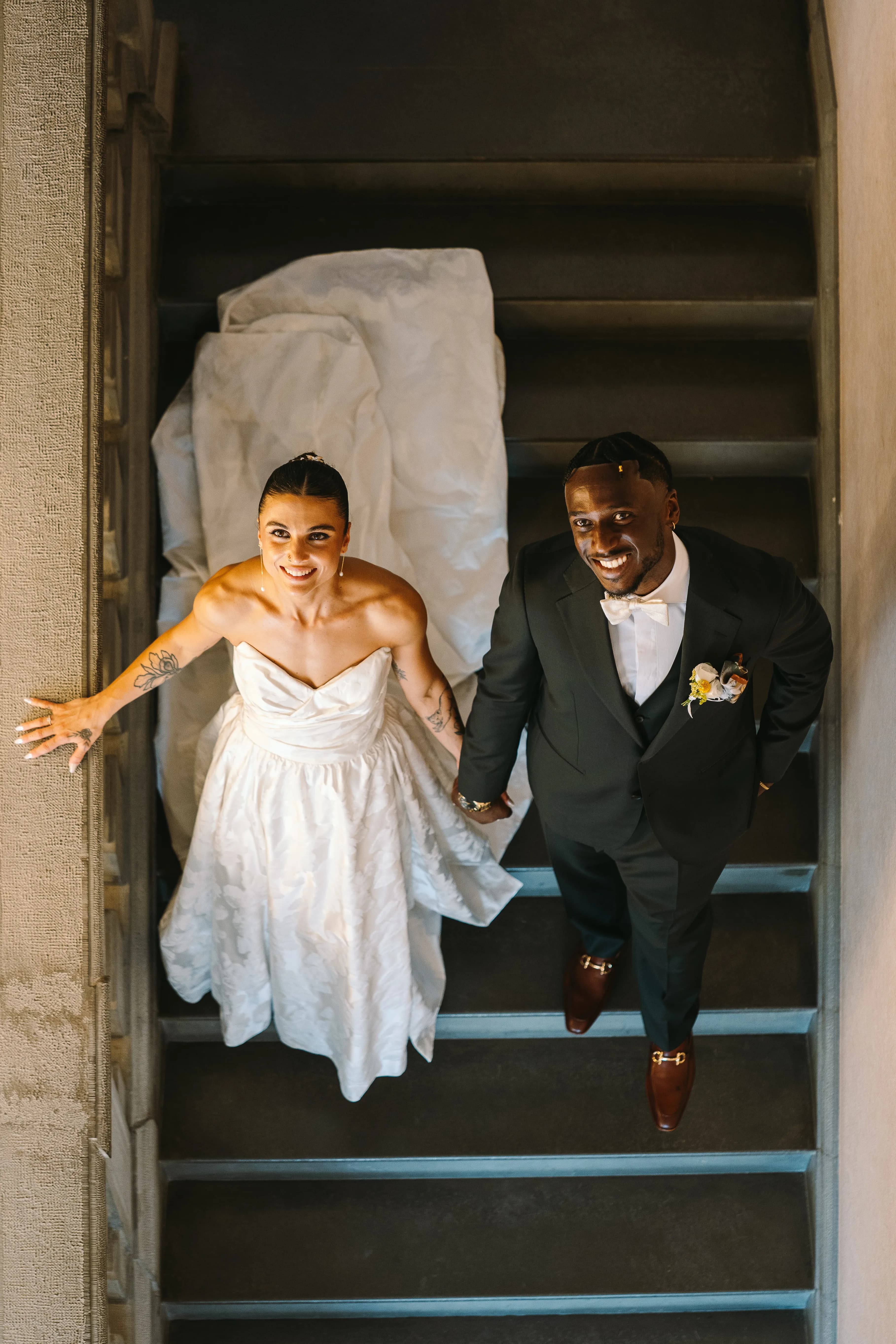 Bride and groom seen from above on a staircase, Isa and Madu’s wedding